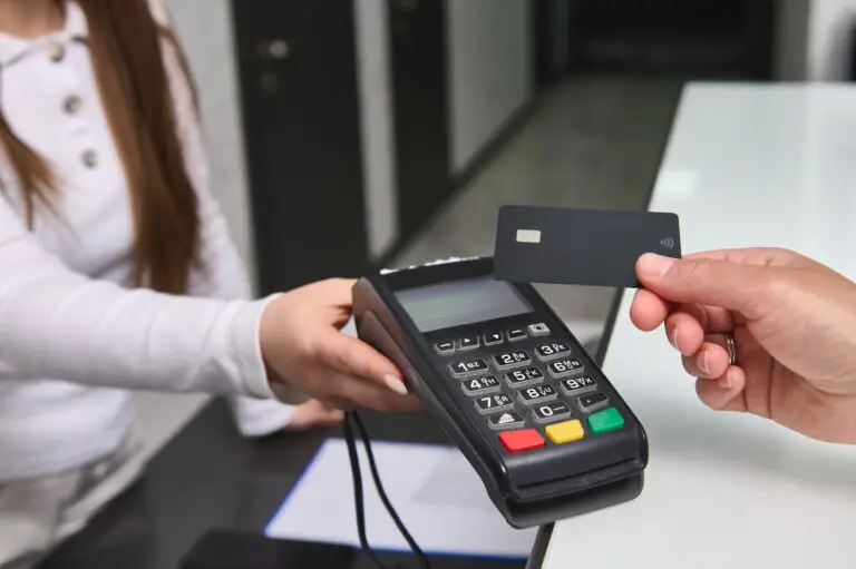 image of a customer tapping to pay with their credit card at a payment terminal held by a woman